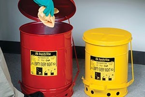 A worker disposing an oily rag into the correct bin